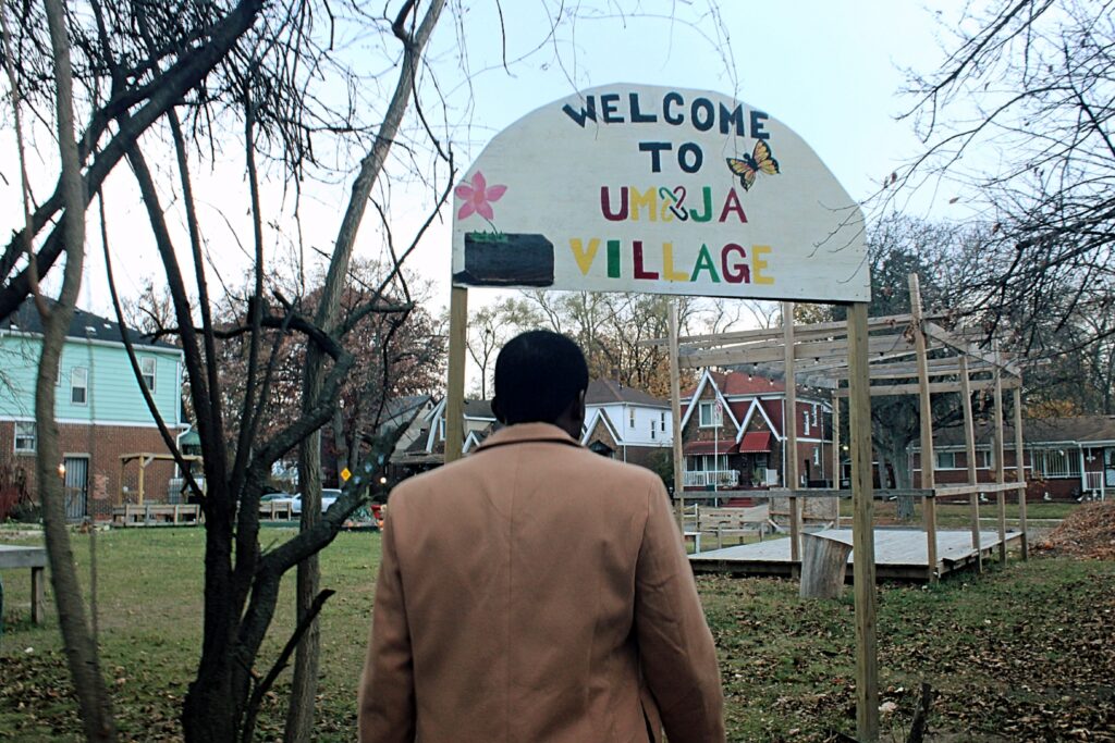 Jerjuan Howard: Community Enhancement Through Literacy Image 5 Grassy field with fallen leaves and several wooden structures, leafless trees.