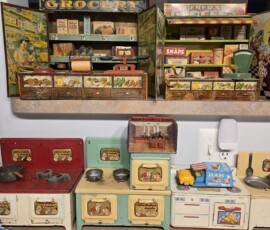 Antique Dollhouse Kitchen photograph of multi-colored miniature kitchen appliances, some with little orphan annie decals applied. Also antique toy farmers market booths. all toys have scruff marks.