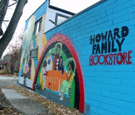 Exterior murals at Howard Family Bookstore in Detroit. Photo ©2025 by Ryan M Place. All rights reserved. Side wall of a brick building featuring 3 murals on a blue background.